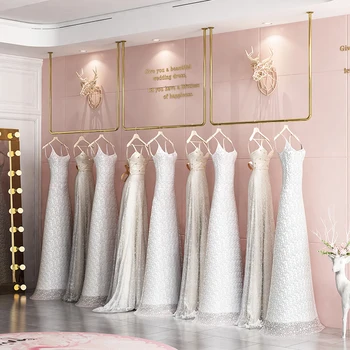 Nerūsējošā tērauda kāzu kleitu display rack U-formas zelta griestiem karājas pakaramais uz augšējo sienas sieviešu apģērbu veikals